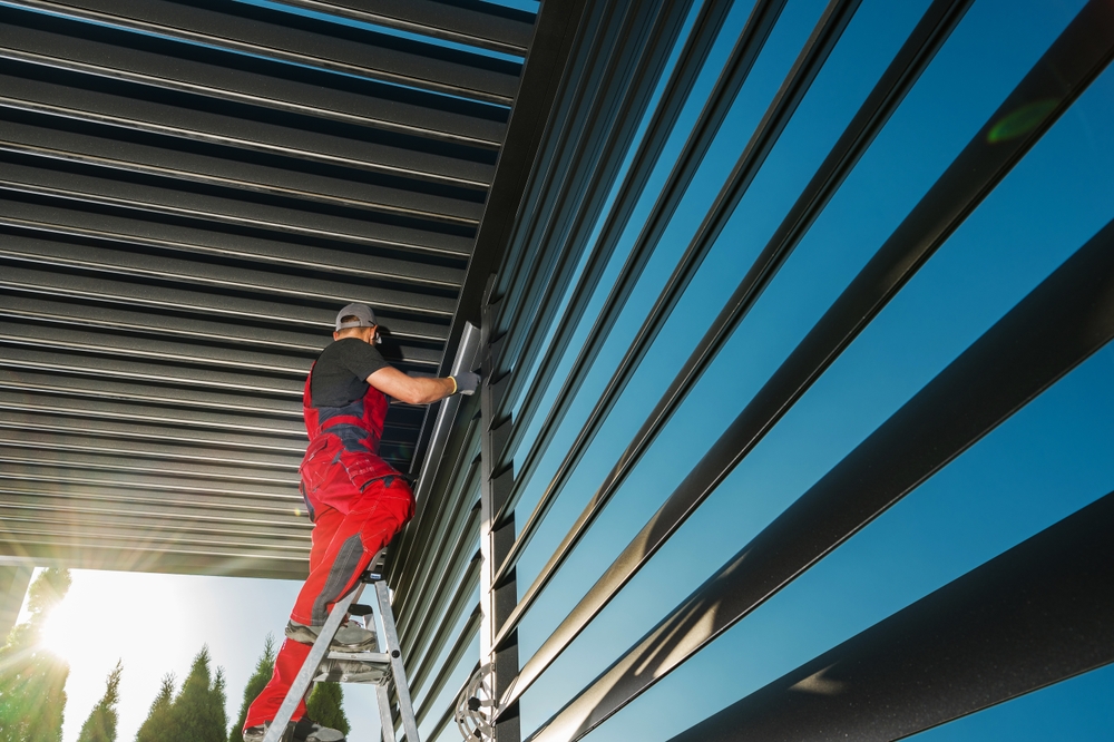 Installer working on modern louvre roof system outdoor installation Tauranga