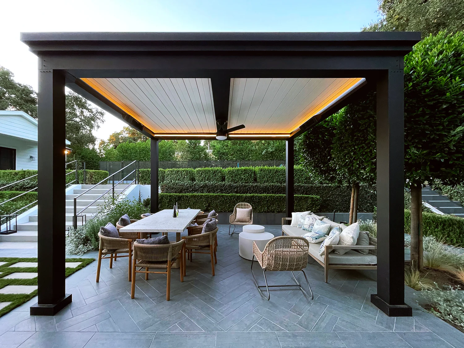 Modern outdoor pergola with dining and lounge area in landscaped backyard Tauranga